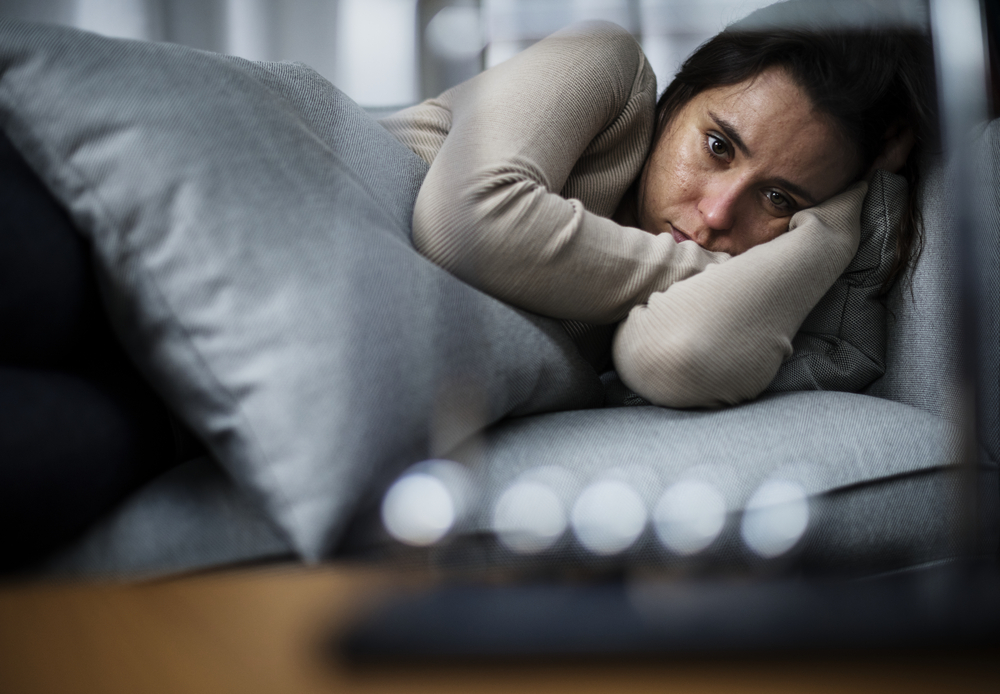 woman laying in bed looking sad