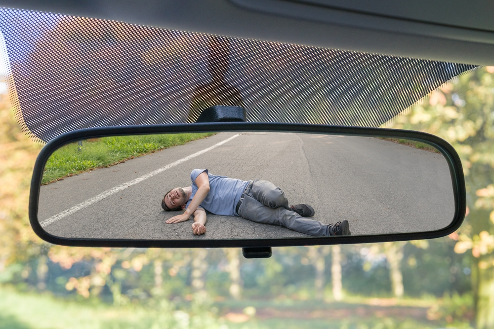 rear view mirror showing injured person from hit and run